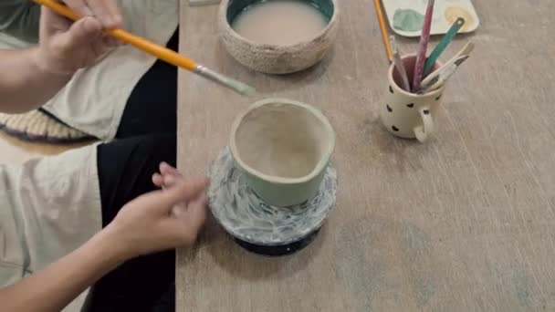 Stüdyoda Çömlek Çarkının Üzerindeki Killi Kupaları Boyayan Ellerin Açılı Görüntüsünü — Stok video