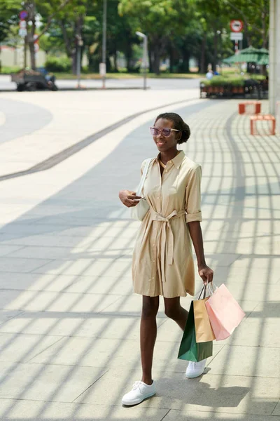 商店街を歩くたくさんの買い物袋を持つ幸せな若い女性 週末の活動のコンセプト — ストック写真