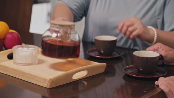 早餐时将茶倒入杯子中的女性手的中等距离特写 — 图库视频影像