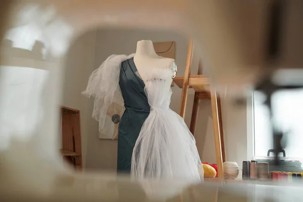 Mannequin with draped fabric in studio of fashion designer