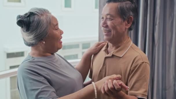 Средний Снимок Улыбающейся Пожилой Пары Обнимающей Друг Друга Танцующей Гостиной — стоковое видео