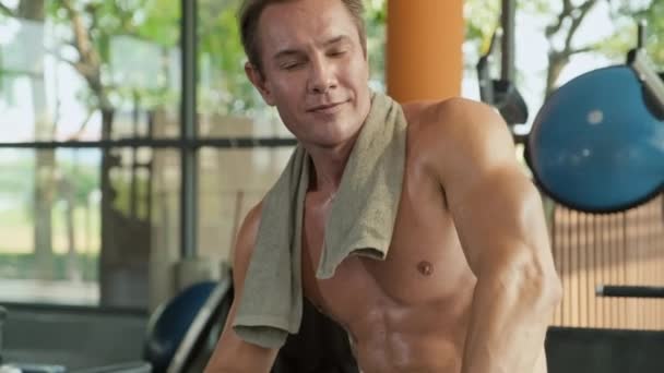成年赤身裸体男子在健身房训练后用毛巾擦拭脸 看镜头的肖像 — 图库视频影像