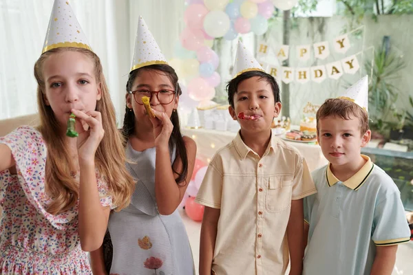 一群快乐的孩子在生日派对上吹喇叭 — 图库照片