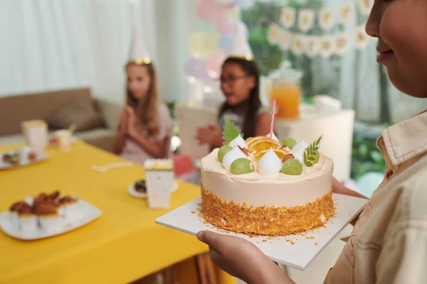 テーブルにろうそくを持ってケーキをもたらす笑顔の誕生日の少年の作物のイメージ — ストック写真