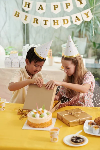 好奇的孩子在生日派对上打开礼物 — 图库照片