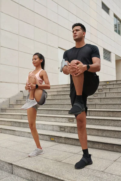 年轻夫妇在跑前伸腿热身 — 图库照片