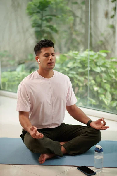 Evde Alıştırma Yaparken Kulaklıkla Meditasyon Yapan Sakin Bir Adam — Stok fotoğraf