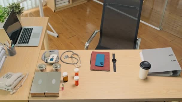 医生工作场所 附有药丸的办公桌 智能卡 听诊器和咖啡的高透视 — 图库视频影像