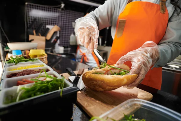 Mani Guantate Cuoco Mettendo Verdi Sandwich Carne — Foto Stock