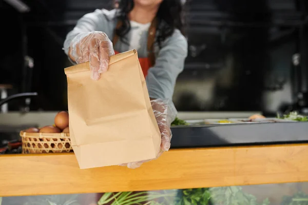 食品卡车工人戴着手套 提供装有熟食的纸袋 — 图库照片