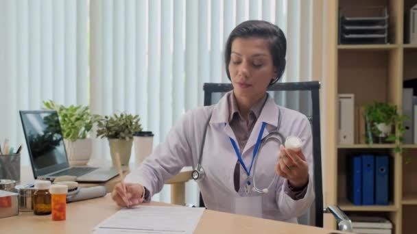 Üniformalı Kadın Doktor Yerindeki Dolapta Otururken Hastaya Ilaç Yazıyor — Stok video