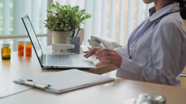 Kadın Doktorun Dolap Başında Otururken Dizüstü Bilgisayar Kullanarak Hastaların Teşhisi — Stok video