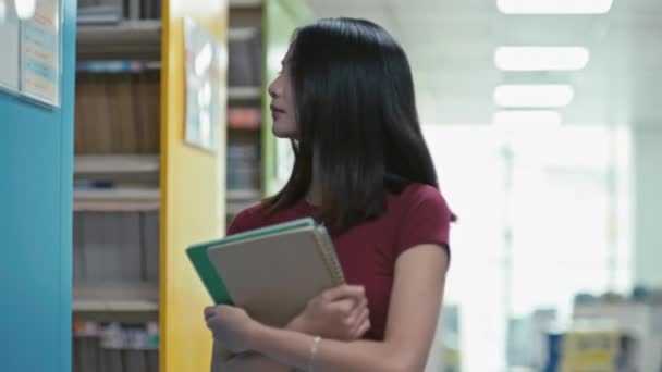 Közepes Felvétel Női Hallgatók Séta Könyvtár Sorban Keresi Megfelelő Könyvet — Stock videók