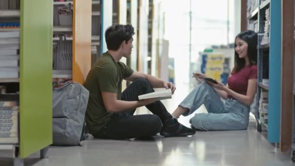 Genç Üniversite Öğrencileri Kütüphane Zemininde Oturup Kitap Okurken Proje Üzerinde — Stok video