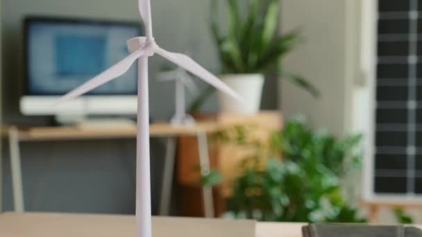エンジニアオフィスのテーブルの上に風力タービンのプラスチックモデルのショットを傾ける — ストック動画