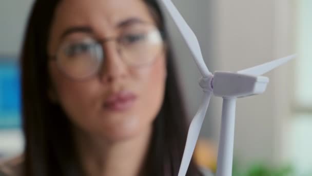 風力タービンのプラスチックモデルを見ている女性エンジニアの閉鎖オフィスでクライアントプロジェクトで働いている間 — ストック動画