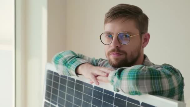 拍照时 穿着休闲装的男人站在太阳能电池板旁边 看着相机 — 图库视频影像