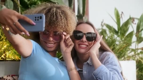 Medelhög Bild Kvinnliga Vänner Solglasögon Som Tar Selfie Medan Umgås — Stockvideo