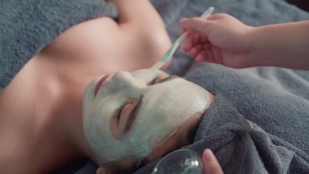 美容院のスパ手順でマスク治療を受ける若い女性クライアントの高角度ビュー — ストック動画