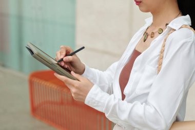 Tablet bilgisayardaki dökümanı dolduran iş kadınının kırpılmış resmi