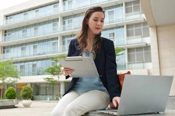 Genç Kadını Dışarıda Bankta Oturuyor Belgelerle Çalışıyor Verileri Dizüstü Bilgisayarla — Stok fotoğraf