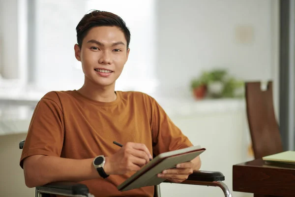 平板电脑上兴奋的亚洲残疾大学生的肖像 — 图库照片