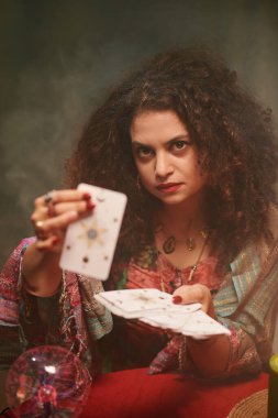Tarot kartları gösteren ciddi bir büyücünün portresi, falcılık konsepti
