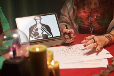 Falcı astroloji doğum çizelgesini okuyor ve yorumluyor.