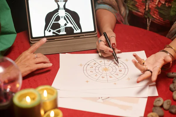 占星術師は 女性のクライアントの自然なチャートを分析し 彼女のアドバイスを与える — ストック写真