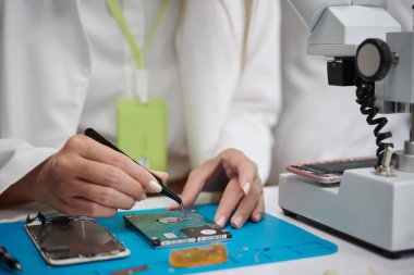 Elektronik tamir için cımbız kullanan teknisyenlerin yakın plan resmi