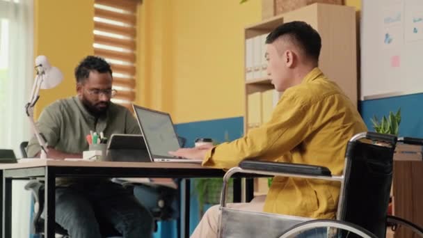 Tekerlekli Sandalyedeki Genç Adamın Ofiste Dizüstü Bilgisayarla Çalışırken Orta Boy — Stok video
