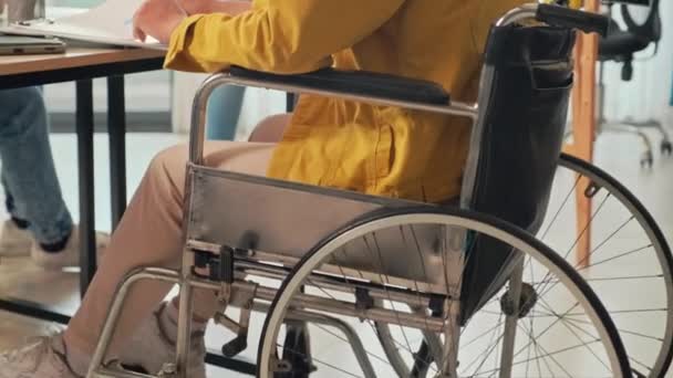 Tekerlekli Sandalyedeki Genç Adamı Arkadaşlarıyla Projelerini Tartışırken Ofiste Notlar Alırken — Stok video