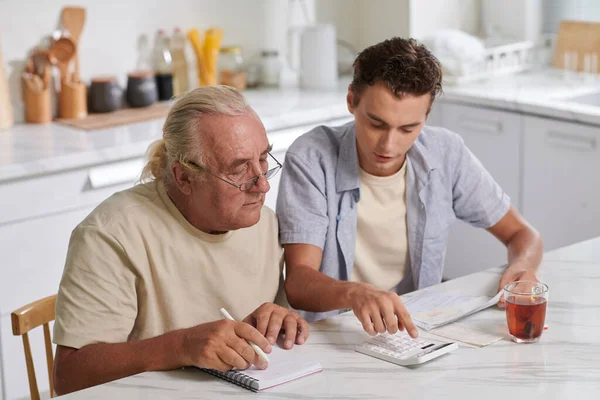 Grandson Helping Grandfather Calculate Expenses — Stock Photo, Image