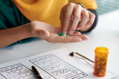 Stresli Müslüman UI tasarımcısının elleri antidepresan haplar alıyor.