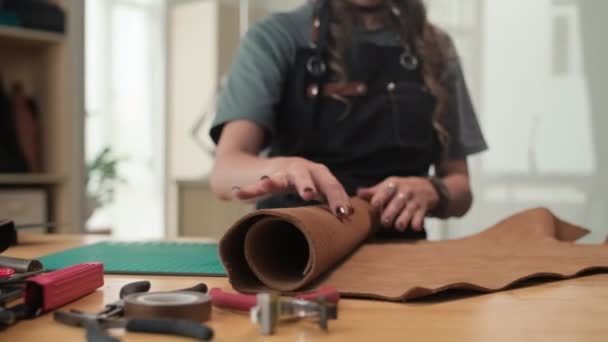 Обрезанный Снимок Женщины Выкатывающей Кусок Кожи Изготовления Сумки Клиента Мастерской — стоковое видео