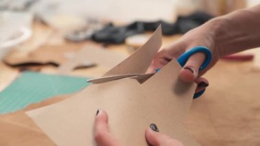 Deri atölyesinde çalışırken karton desenleri kesen zanaatkar kadınların ellerini kapatın.