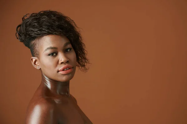 カメラを見ている現代的なヘアスタイルの深刻な若い黒人女性のスタジオの肖像画 — ストック写真