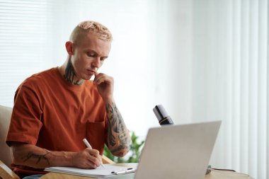 Somurtkan blog yazarı, sosyal medyası için podcast yapmadan önce betiği kontrol ediyor