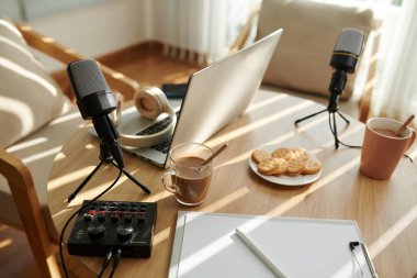 Podcaster ve misafiri için bir fincan kahve ve kurabiye.
