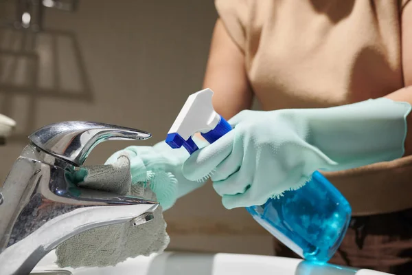 스프레이 세제를 사용하여 화장실 탭에서 단단한 얼룩을 제거하는 서비스 노동자 — 스톡 사진