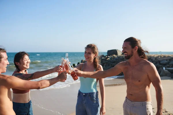 Grupo Amigos Alegres Tintineando Botellas Vidrio Disfrutar Fiesta Playa —  Fotos de Stock