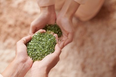 Bir avuç dolusu krep ve mikroplastik saçmalar tutan kadının elleri.