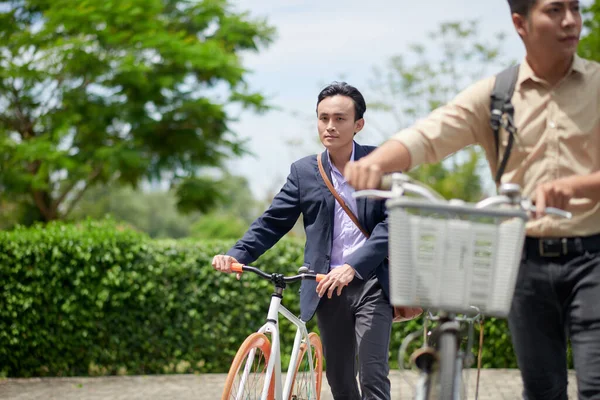 Poważny Wietnamski Biznesmen Spaceru Obok Roweru Podczas Przekraczania Drogi — Zdjęcie stockowe