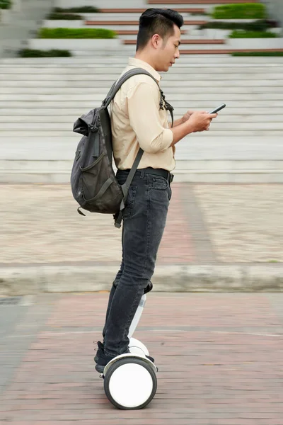 Vietnamese Jongeman Controleert Meldingen Smartphone Tijdens Het Rijden Campus Van — Stockfoto