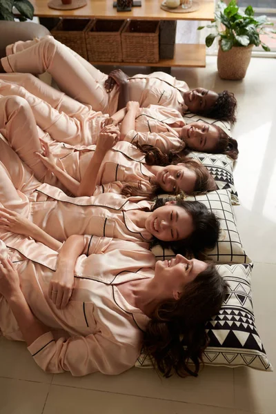 Счастливые Молодые Женщины Атласной Пижаме Лежат Полу Улыбаясь Глядя Друг — стоковое фото