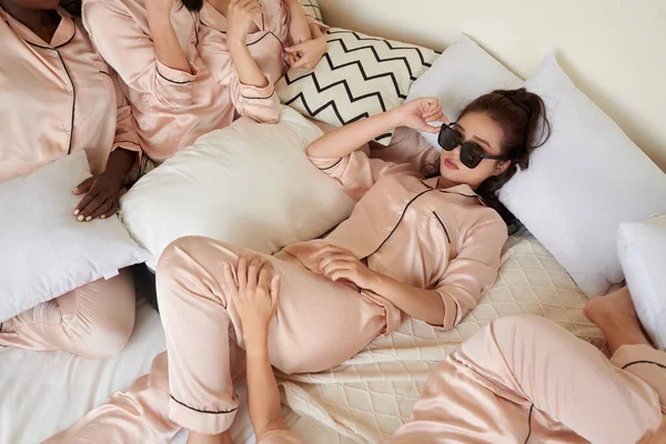 Cool Ung Kvinna Satin Pyjamas Liggande Sängen Tar Solglasögon Och — Stockfoto
