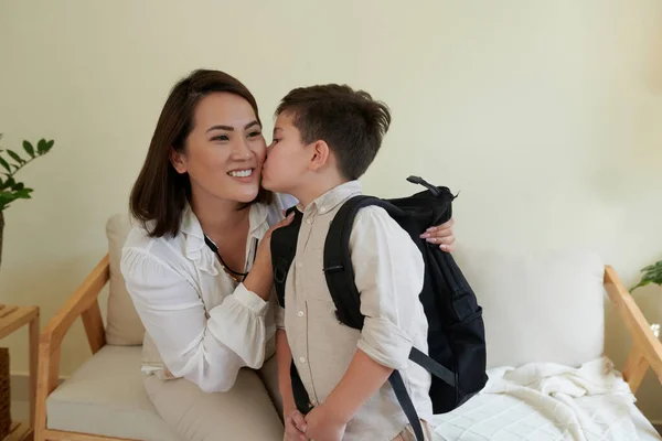 小さな男の子は学校に出発するときに頬に笑顔の母親にキス — ストック写真