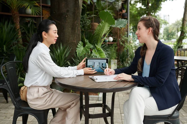 Smiling woman meeting with real estate agent in outdoor cafe