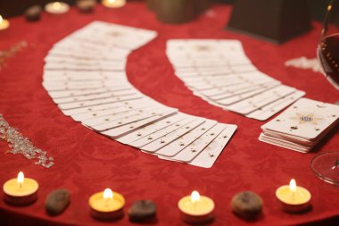 Tarot kartları kırmızı bezle kaplı masaya yayılmış.