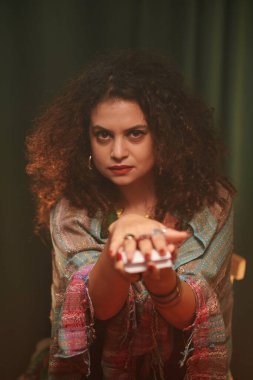 Ciddi bir falcının portresi müşterisinden tarot kartını elinden almasını istiyor.